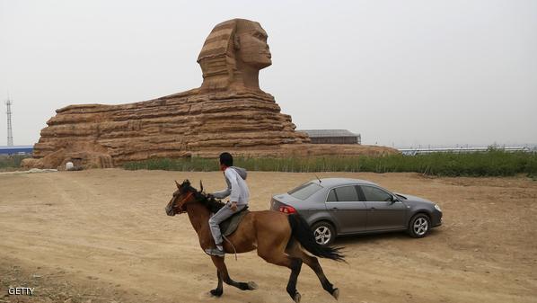 A man rides a horse past a full-scale replica of the Sphinx on the outskirts of Shijiazhuang